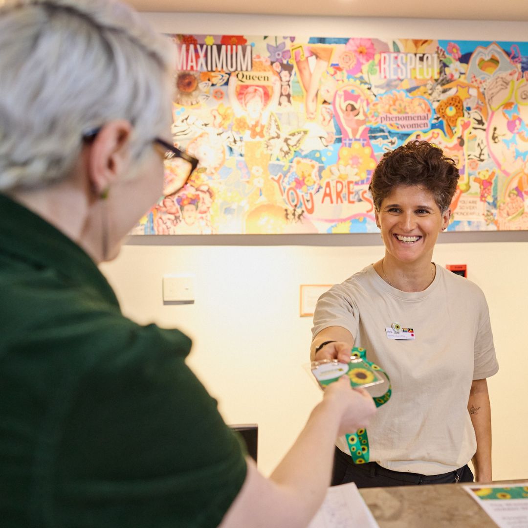 Vera Ciavarella, Disability Liaison Officer at the Women's, gives out a Sunflower lanyard. 